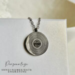 Custom-engraved pendant with song lyrics for a meaningful keepsake Caption: Engrave any song lyrics onto a vinyl record pendant, making it a keepsake for special moments.