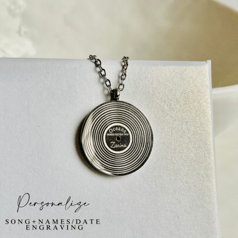Custom-engraved pendant with song lyrics for a meaningful keepsake Caption: Engrave any song lyrics onto a vinyl record pendant, making it a keepsake for special moments.